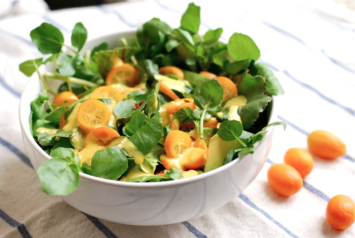 A colorful watercress and avocado salad with beet greens and kumquat slices, tossed with a punchy kumquat dressing.