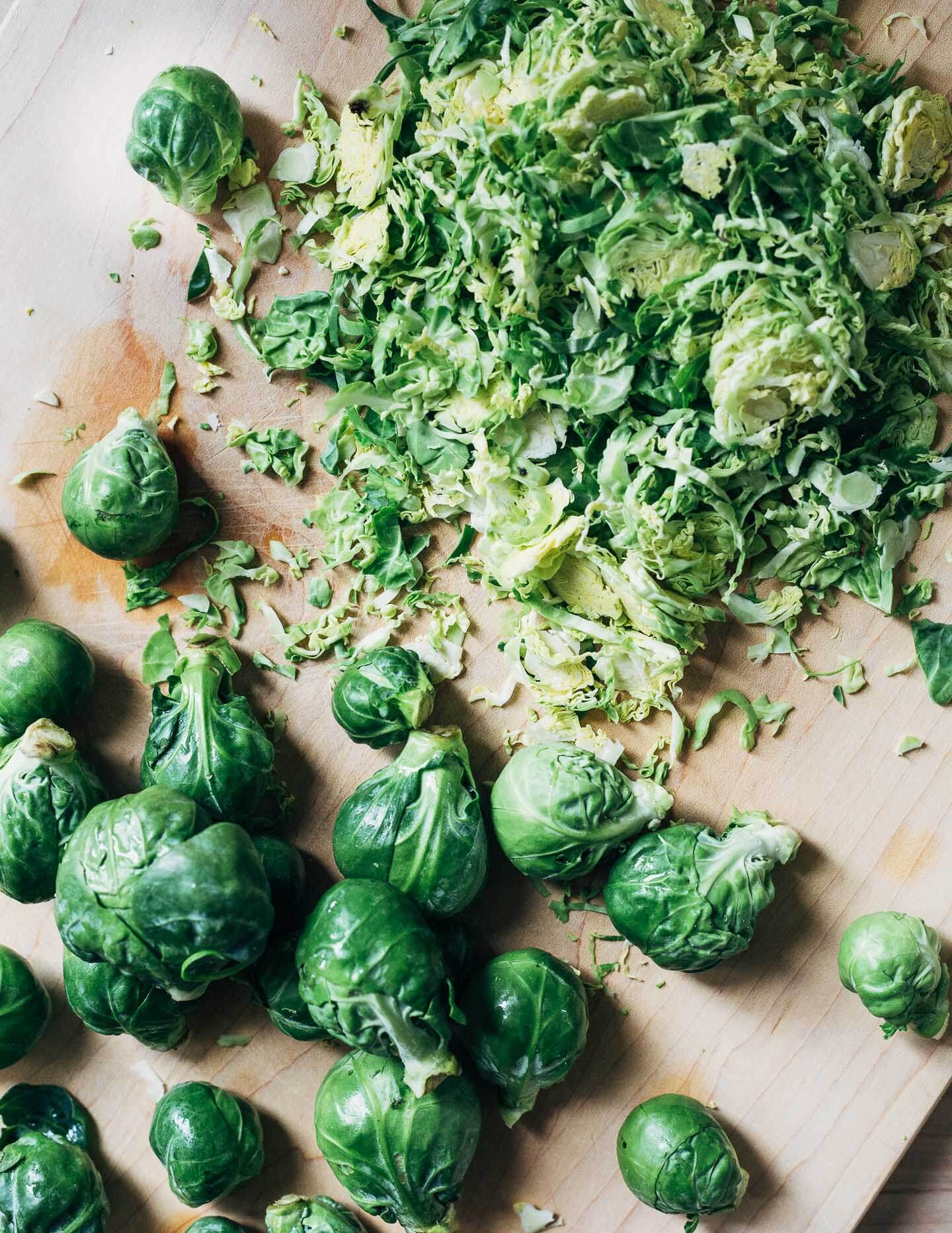 A cutting board with shaved Brussels sprouts. 