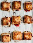 A baking sheet with nine square strawberry basil hand pies, just out of the oven.