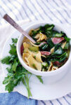 A bowl of ham hock and collard soup garnished with parsley.