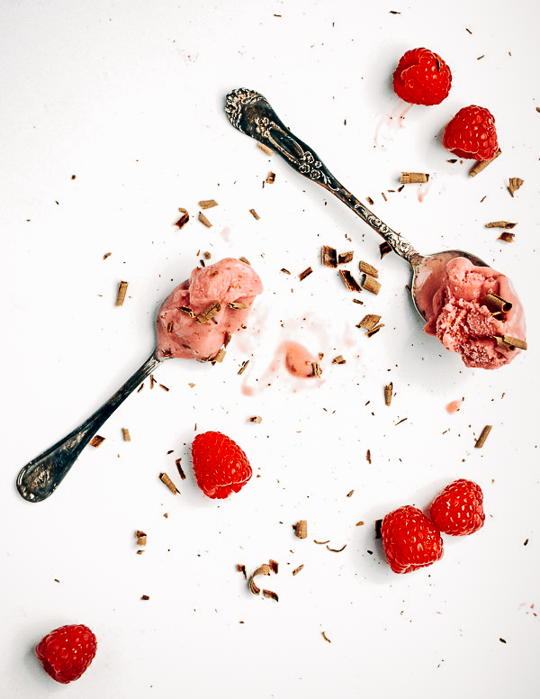 Two spoons of raspberry yogurt with raspberries and chocolate