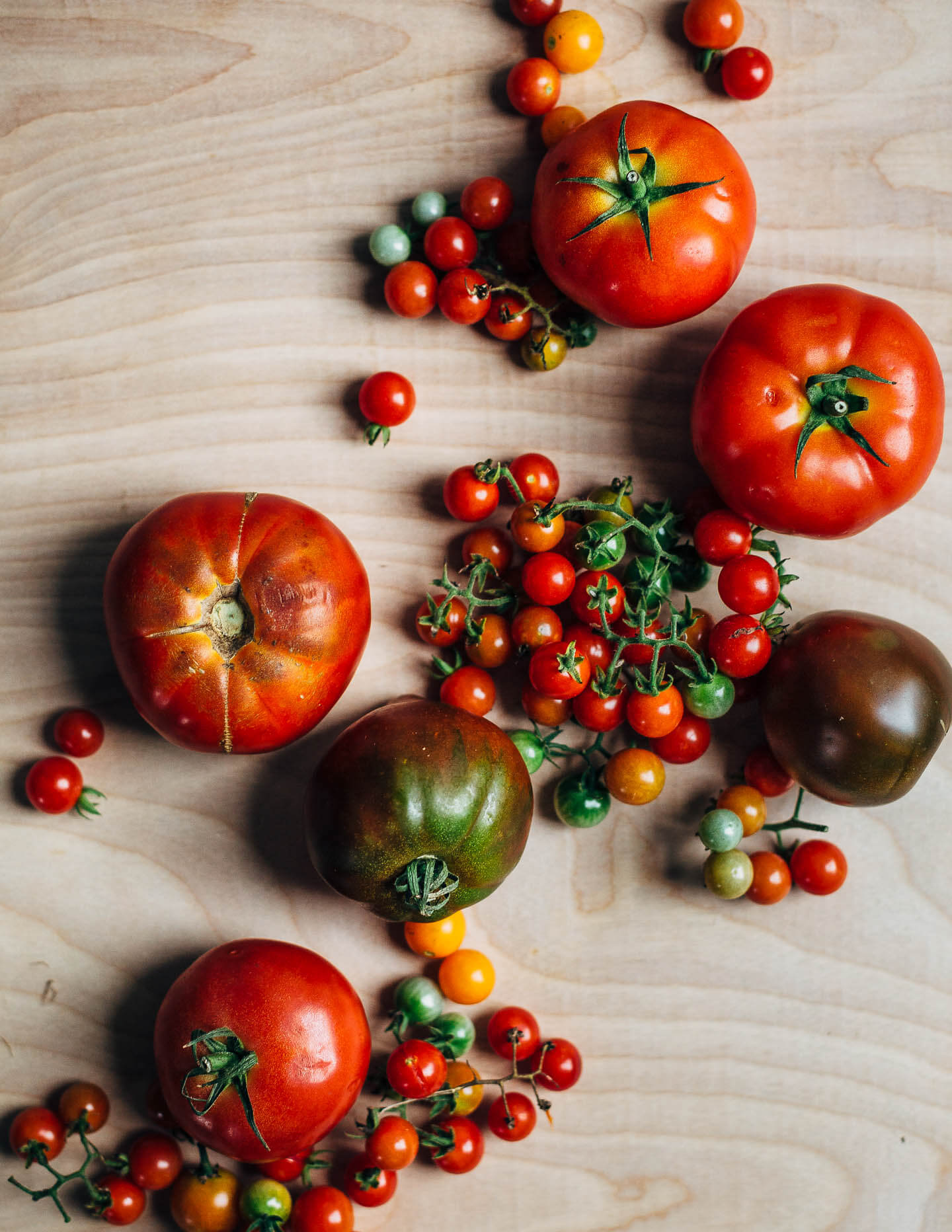 Fresh heirloom tomatoes arranged on a tabletop. 