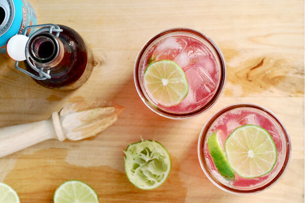 Two cocktail glasses with a reemer and squeezed limes. 