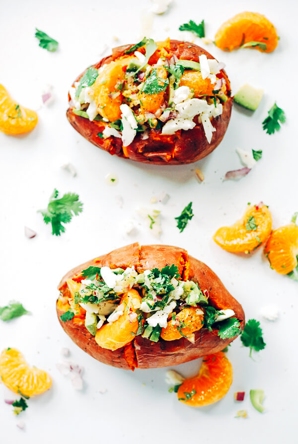 A decadent yet healthy loaded sweet potato recipe that's topped with tangelos, avocado, and haloumi