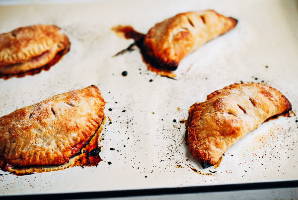 Hand pies, just out of the oven, on a baking sheet. 