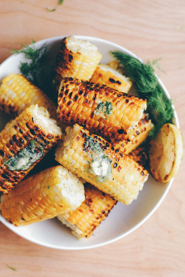 A bowl of grilled corn topped with dill butter