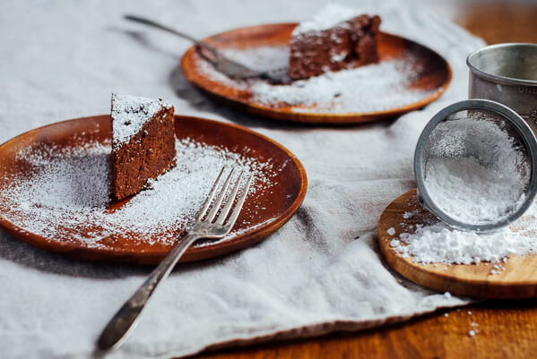 Slices of chocolate cake dusted with powdered sugar. 