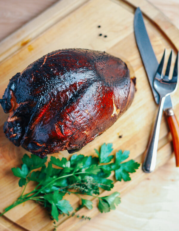 A smoked turkey breast seen overhead on a cutting board. 