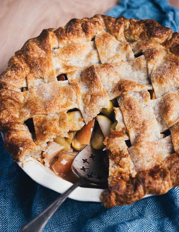 A lady apple pie with a slice taken out. 