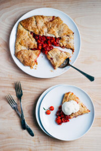 A cherry galette with a slice on a pie server and another slice on a plate.