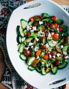 A big bowl with a cucumber and tomato salad