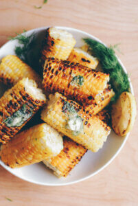 A bowl of grilled corn with dill butter.
