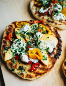 A small grilled pizza with nectarines and peppers.