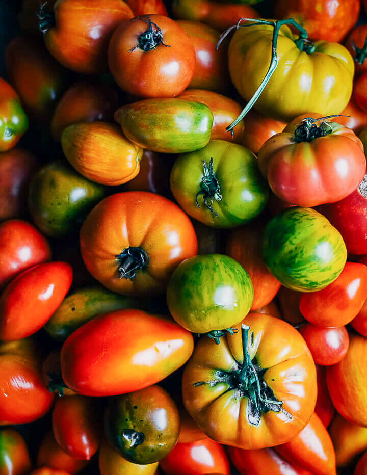 All varieties of tomatoes fill the whole frame. 