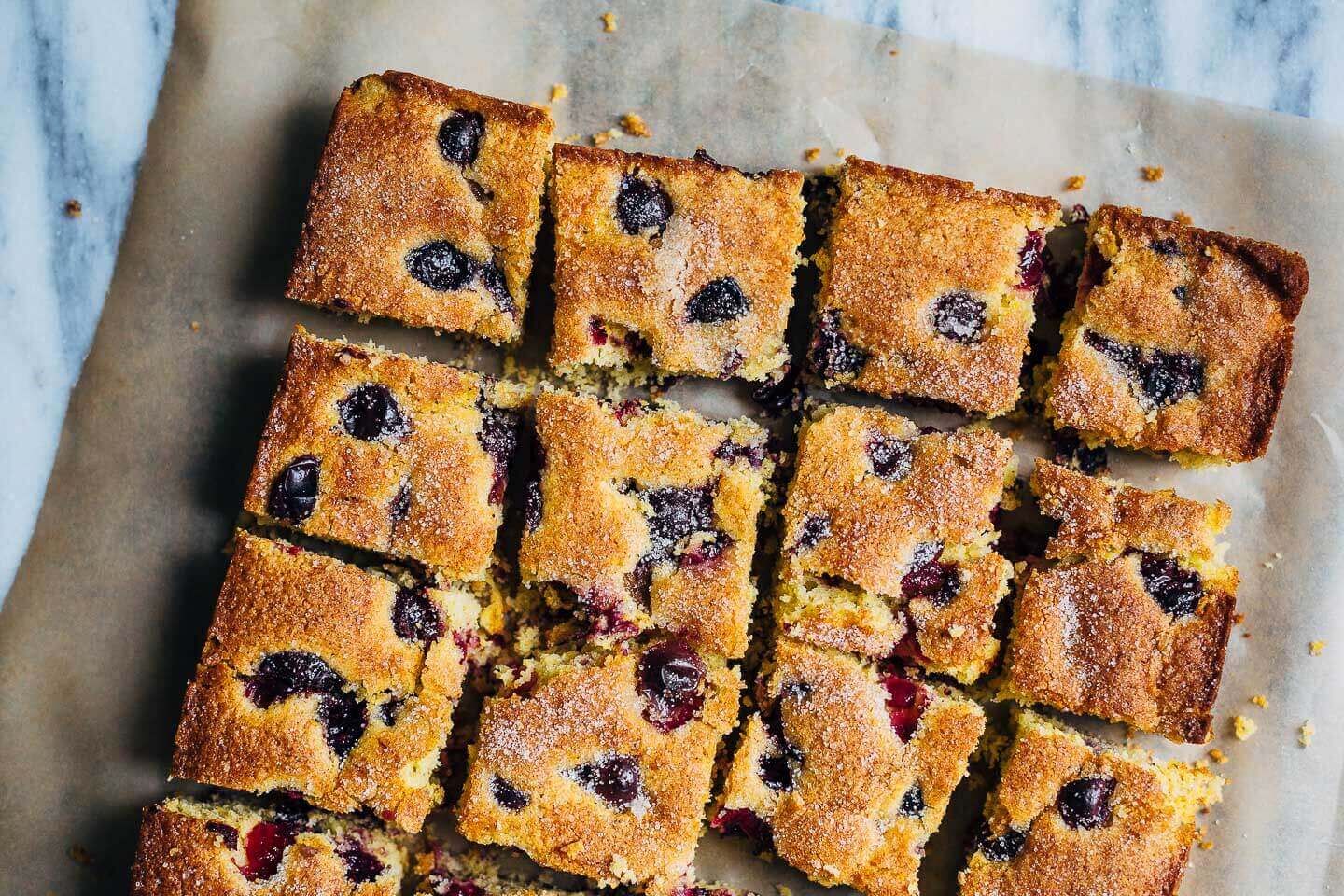 A cornmeal cake with grapes, cut into squares. 