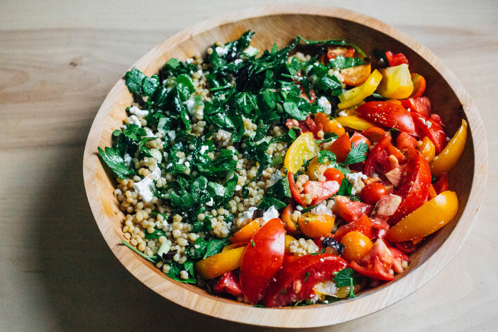 toasted pearl couscous salad with tomatoes and greens