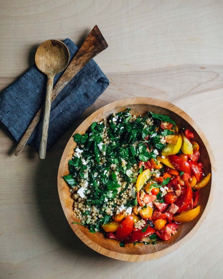 toasted pearl couscous salad with tomatoes and greens