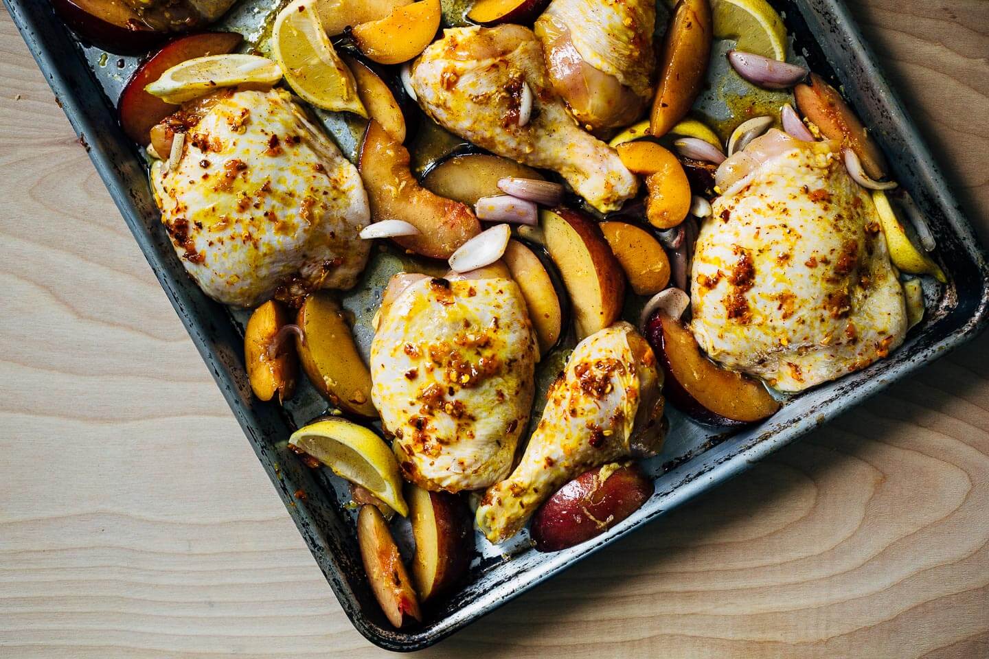 A simple sheet pan chicken and plums recipe featuring crispy saffron- and garlic-infused chicken topped with a sweet and savory plum pan sauce. 