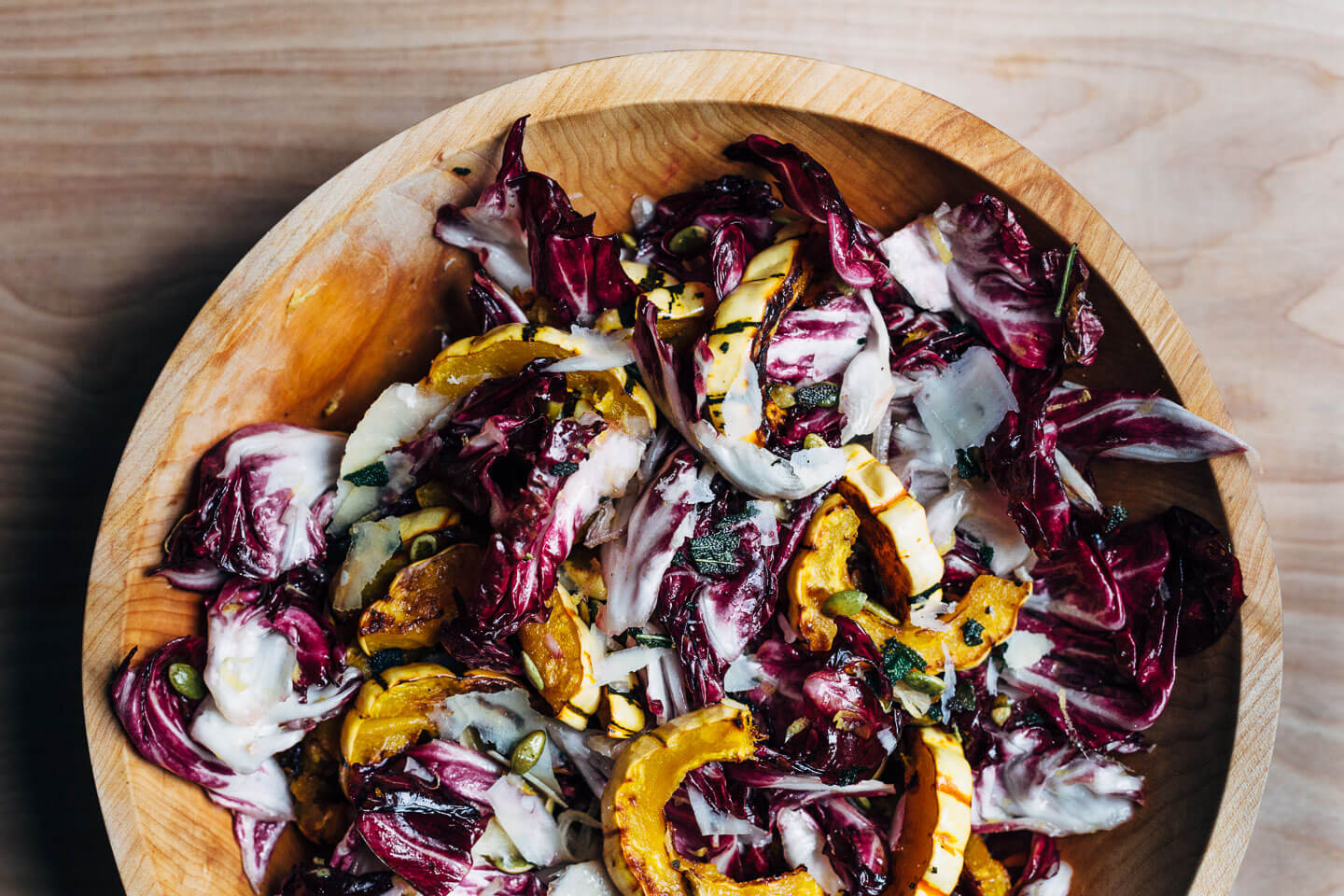An autumnal radicchio and roasted delicata squash salad tossed in a lemon maple dressing, and topped with salty pepitas, fried sage leaves, and Parmesan.