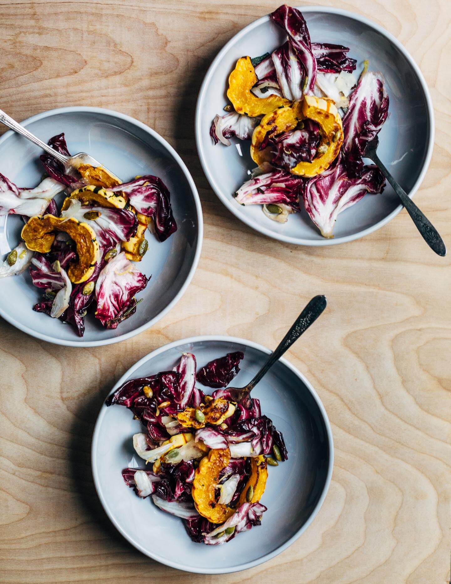 An autumnal radicchio and roasted delicata squash salad tossed in a lemon maple dressing, and topped with salty pepitas, fried sage leaves, and Parmesan.