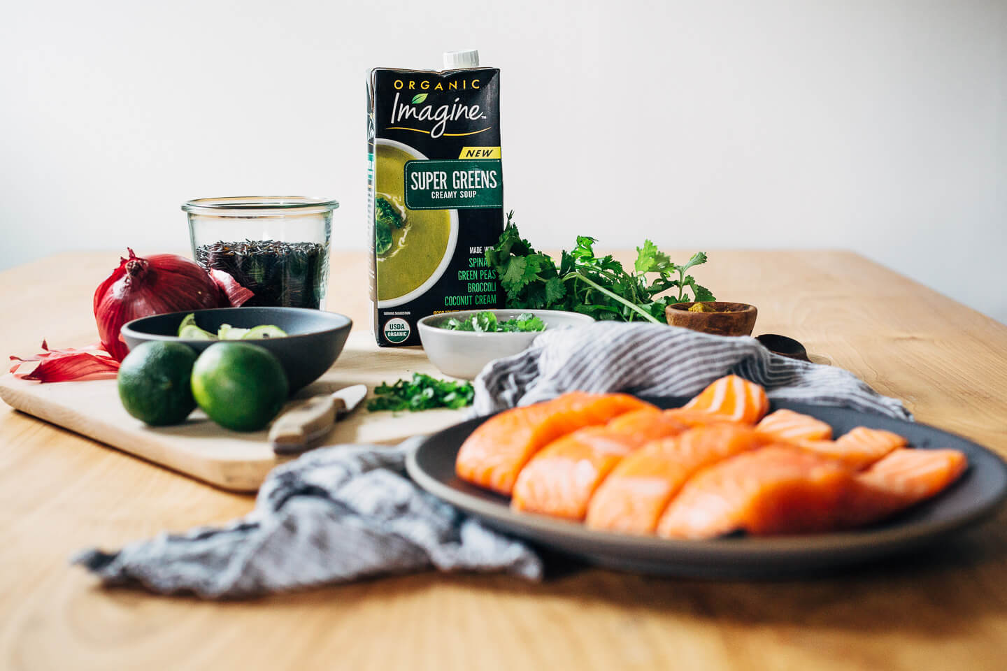 Nourishing green soup with creamy coconut milk and wild rice topped with a pan-seared salmon fillet.