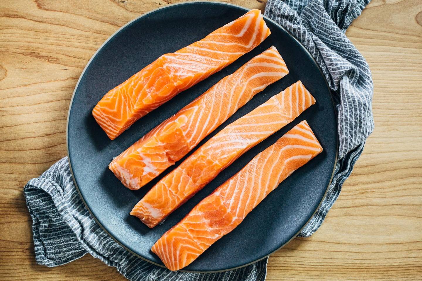 Nourishing green soup with creamy coconut milk and wild rice topped with a pan-seared salmon fillet.