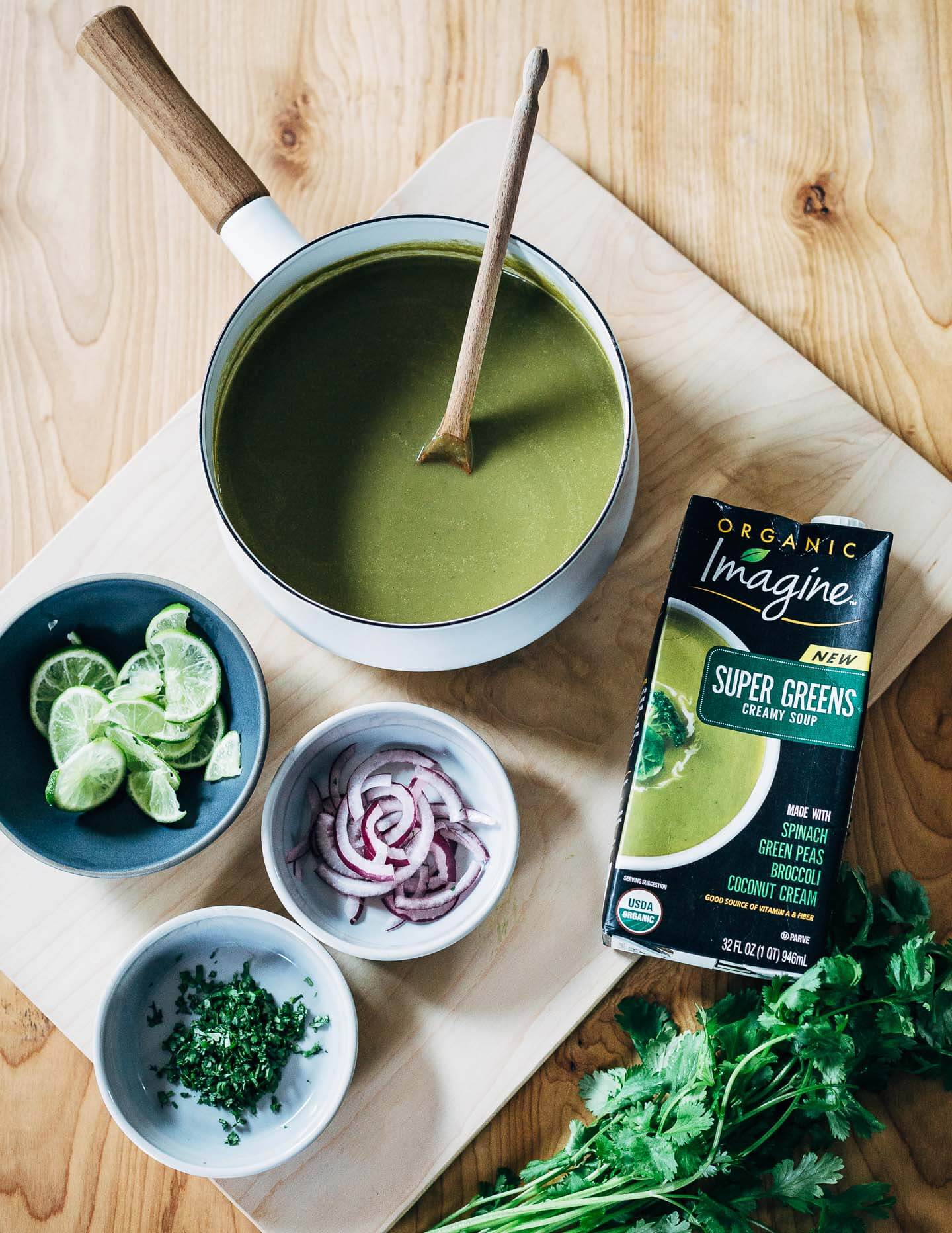 Nourishing green soup with creamy coconut milk and wild rice topped with a pan-seared salmon fillet.