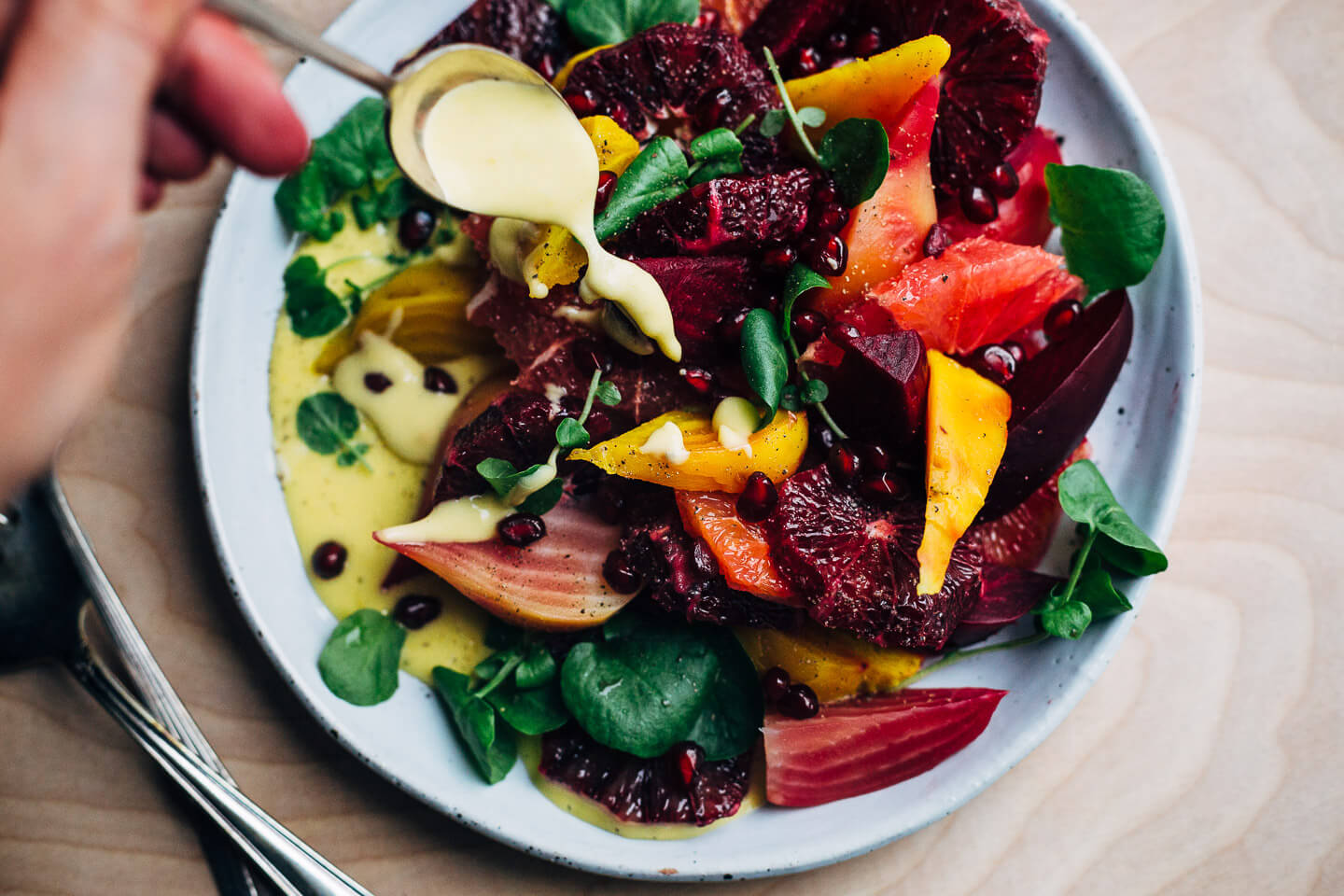 A jewel-toned winter orange and beet salad with layers of Cara Cara and blood oranges, grapefruit segments, red, yellow and chioggia beets, and a creamy homemade grapefruit aioli. 