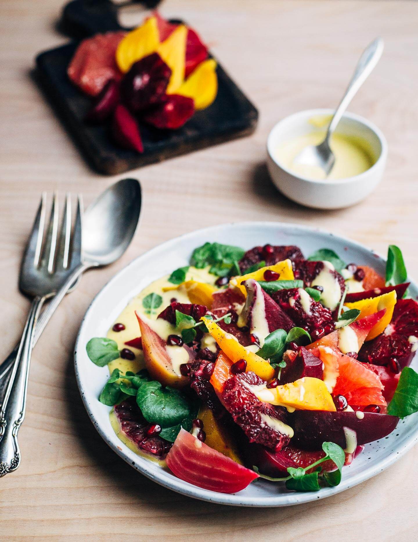 A jewel-toned winter orange and beet salad with layers of Cara Cara and blood oranges, grapefruit segments, red, yellow and chioggia beets, and a creamy homemade grapefruit aioli. 