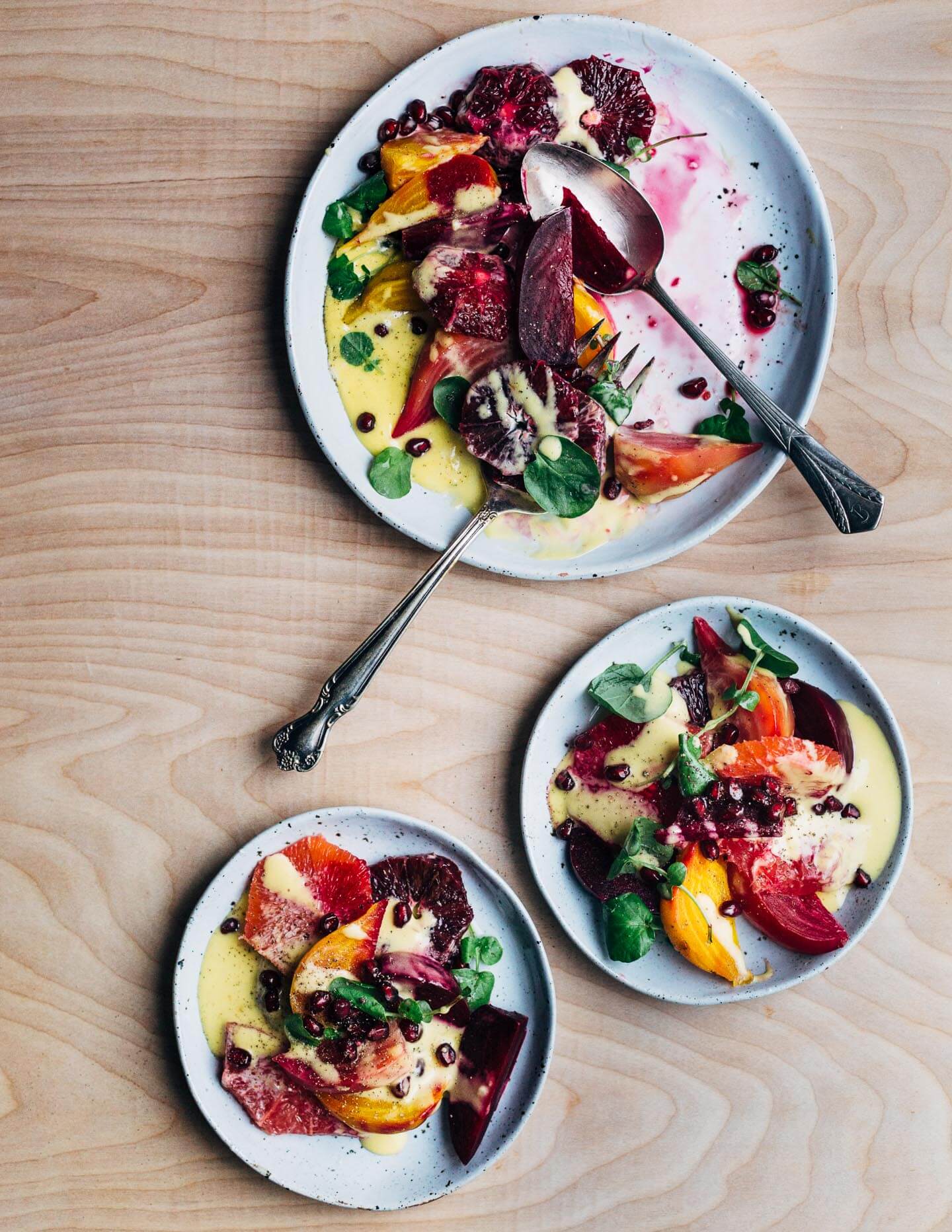 A jewel-toned winter orange and beet salad with layers of Cara Cara and blood oranges, grapefruit segments, red, yellow and chioggia beets, and a creamy homemade grapefruit aioli. 