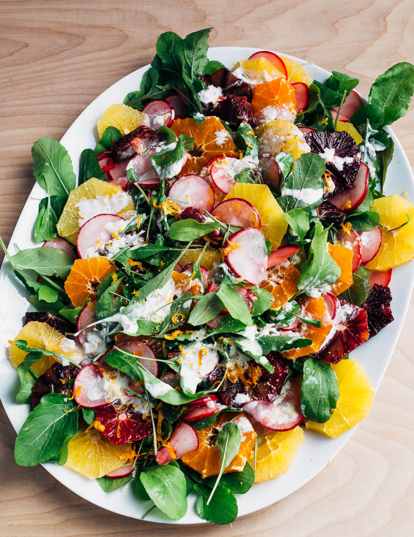 A wintry orange and arugula salad scattered with citrus-marinated radishes and drizzled with creamy buttermilk ranch dressing.