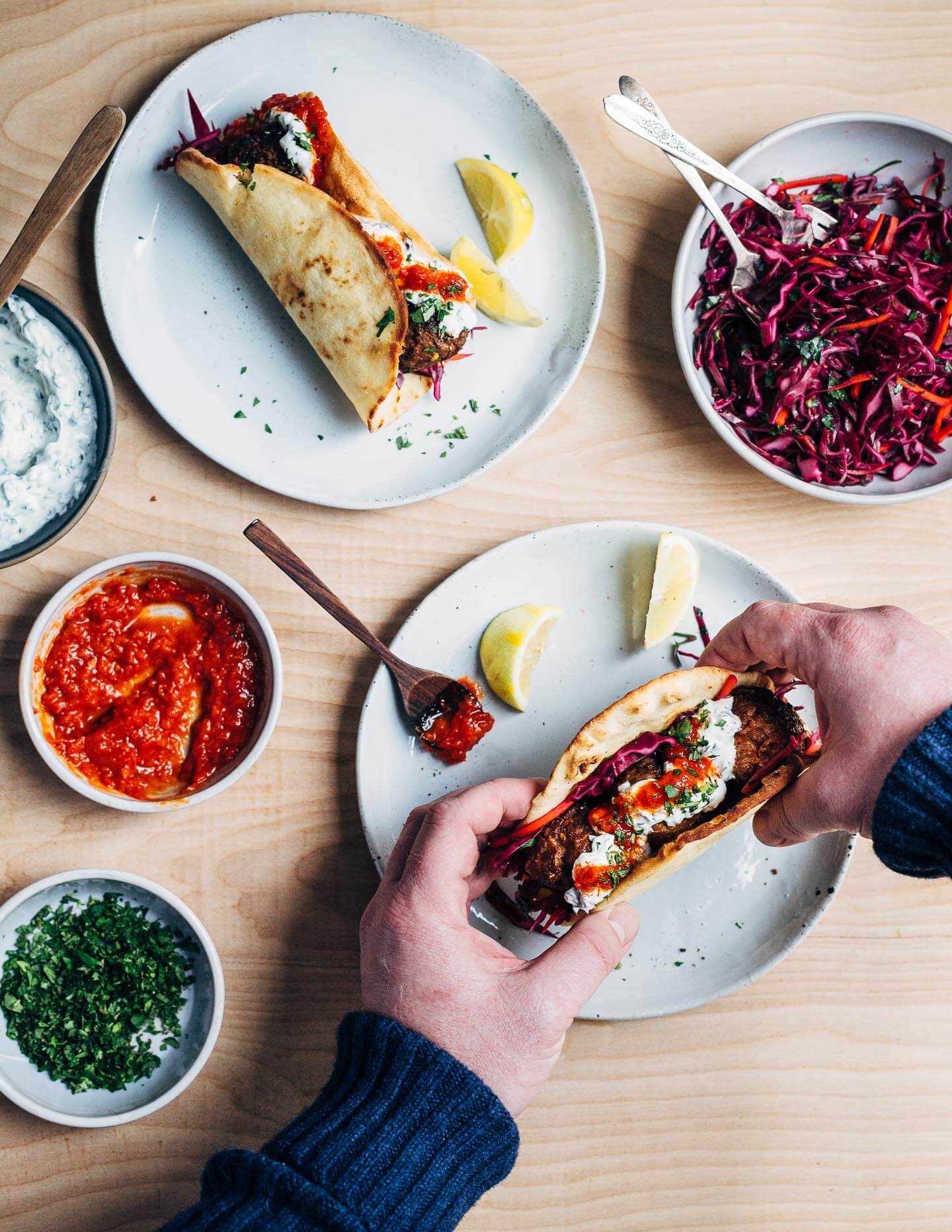 Exceptionally delicious merguez meatball flatbreads layered with red cabbage slaw, herbed yogurt, and harissa. 