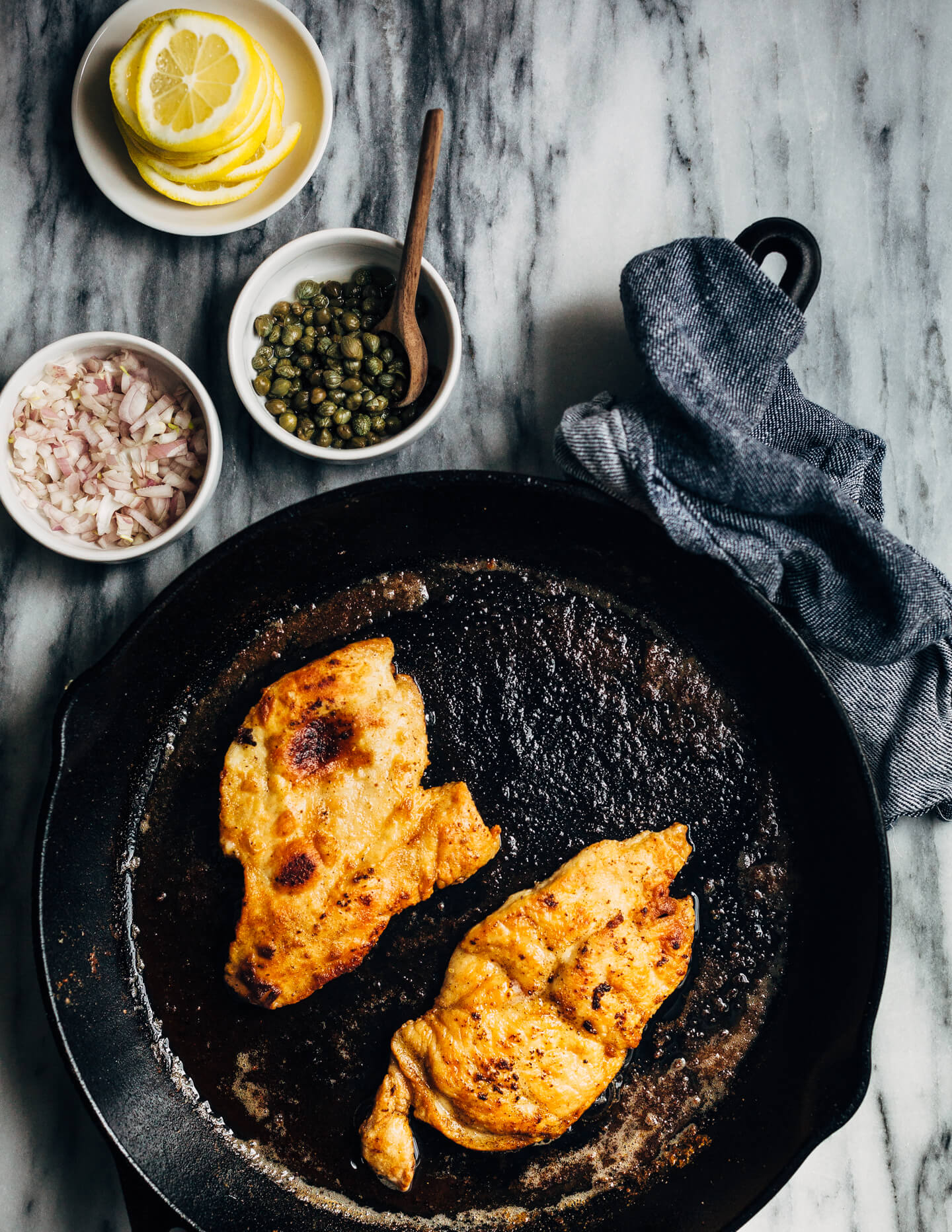 Weeknight-perfect chicken piccata topped with a bright and buttery caper sauce and served alongside angel hair pasta and asparagus.