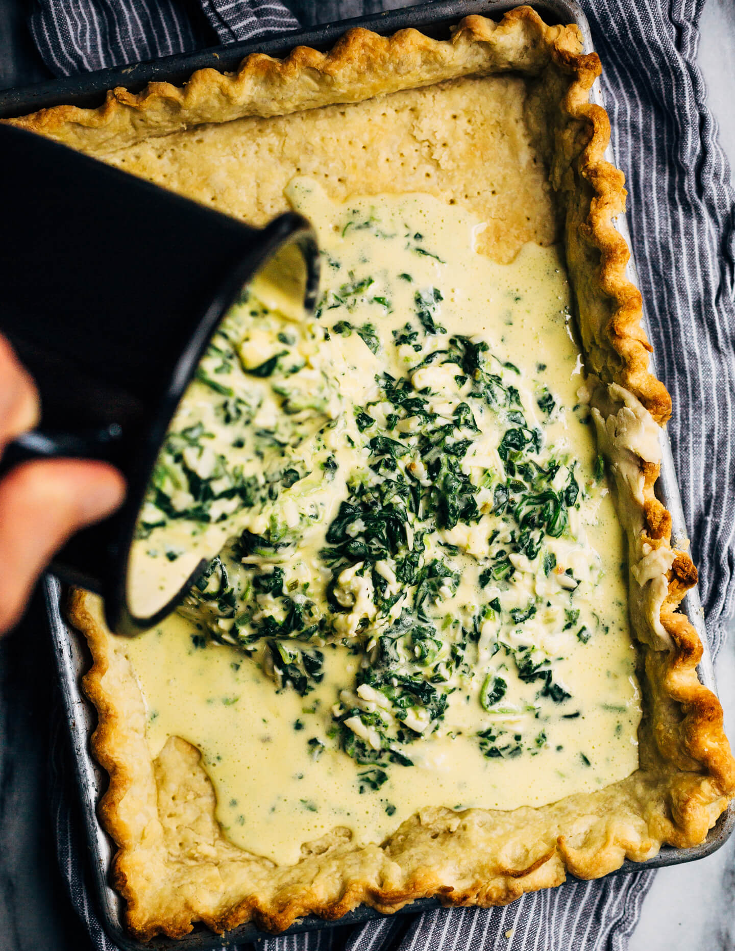 Ideal for Mother's Day brunch or spring gatherings, this sheet pan spinach quiche, made with ramps, green garlic, and chives, is a delicious way to feed a crowd. 