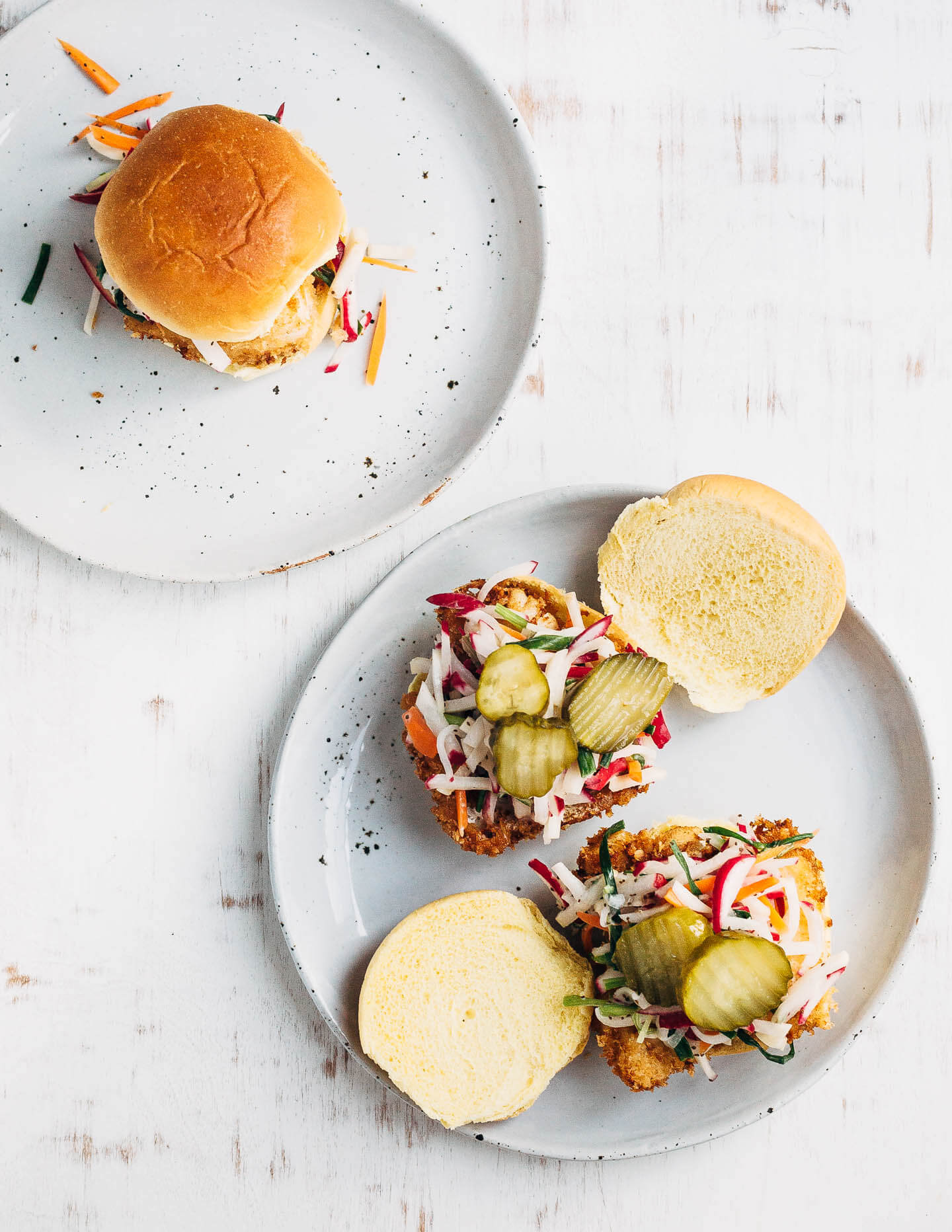 Panko-crusted fried fish sandwiches that are just right for a weeknight at home or a crowd-pleasing feast. Served with a simple radish slaw and bread and butter pickles, these flaky fish sandwiches hit all the right notes.