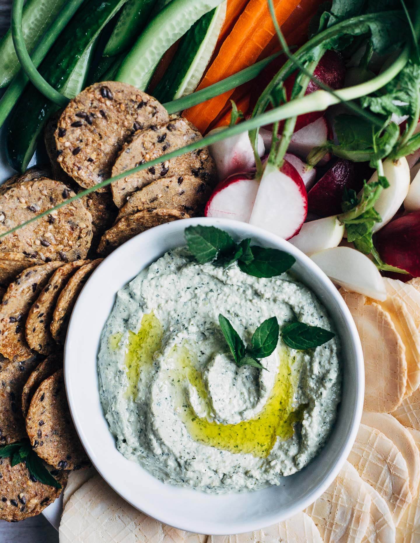This lemony labneh and garlic scape dip is a wonderfully simple appetizer for warm weather fêtes. Creamy labneh, blended with sautéed garlic scapes, fresh mint leaves, and lemon zest, makes for a vibrant, crowd-pleasing dip.