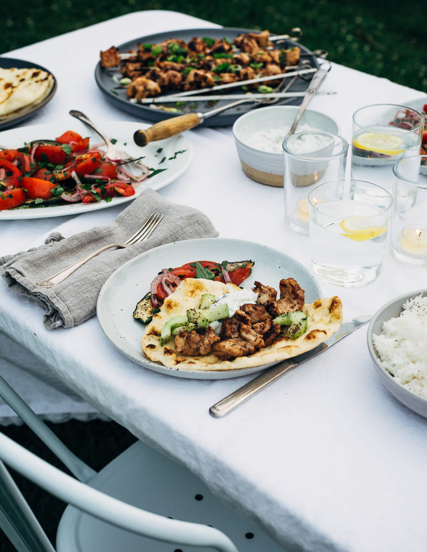 Deliciously tender lemon- and yogurt-marinated grilled chicken kebobs make for a vibrant summer cookout. The grilled chicken skewers are served alongside grilled flatbreads, tzatziki, and an herbed salad made with grilled zucchini, tomato, and red onion.