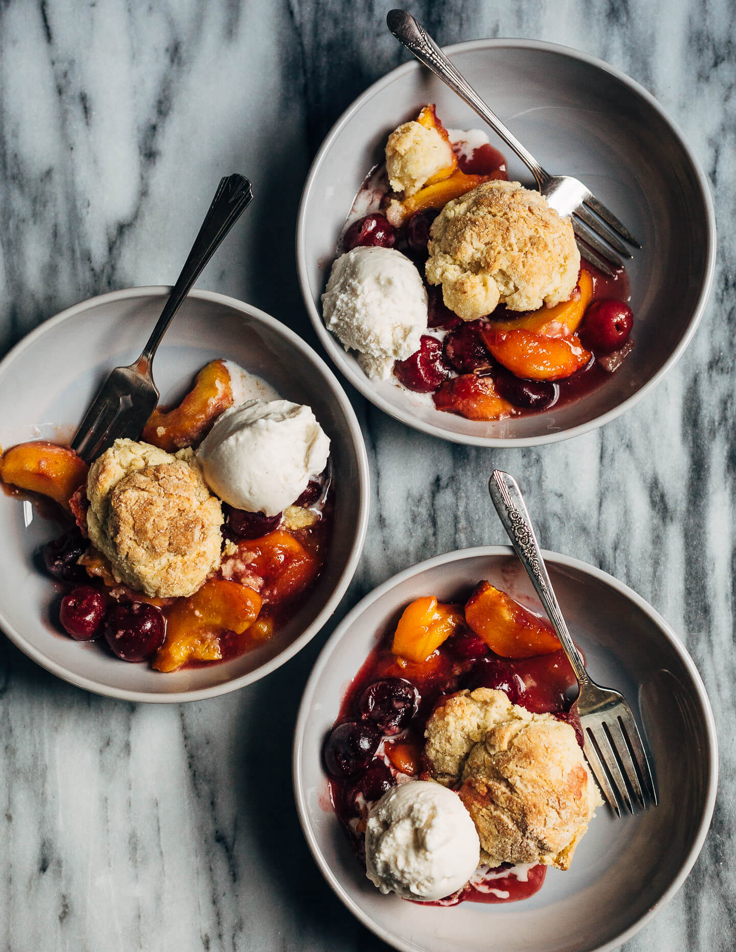 A summery cherry and peach cornmeal cobbler that pairs the sweetness of ripe summer stone fruits with a tender, faintly sweet, cornmeal biscuit topping. 