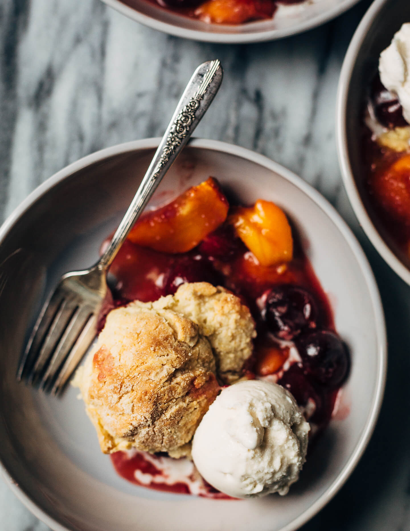 A summery cherry and peach cornmeal cobbler that pairs the sweetness of ripe summer stone fruits with a tender, faintly sweet, cornmeal biscuit topping. 