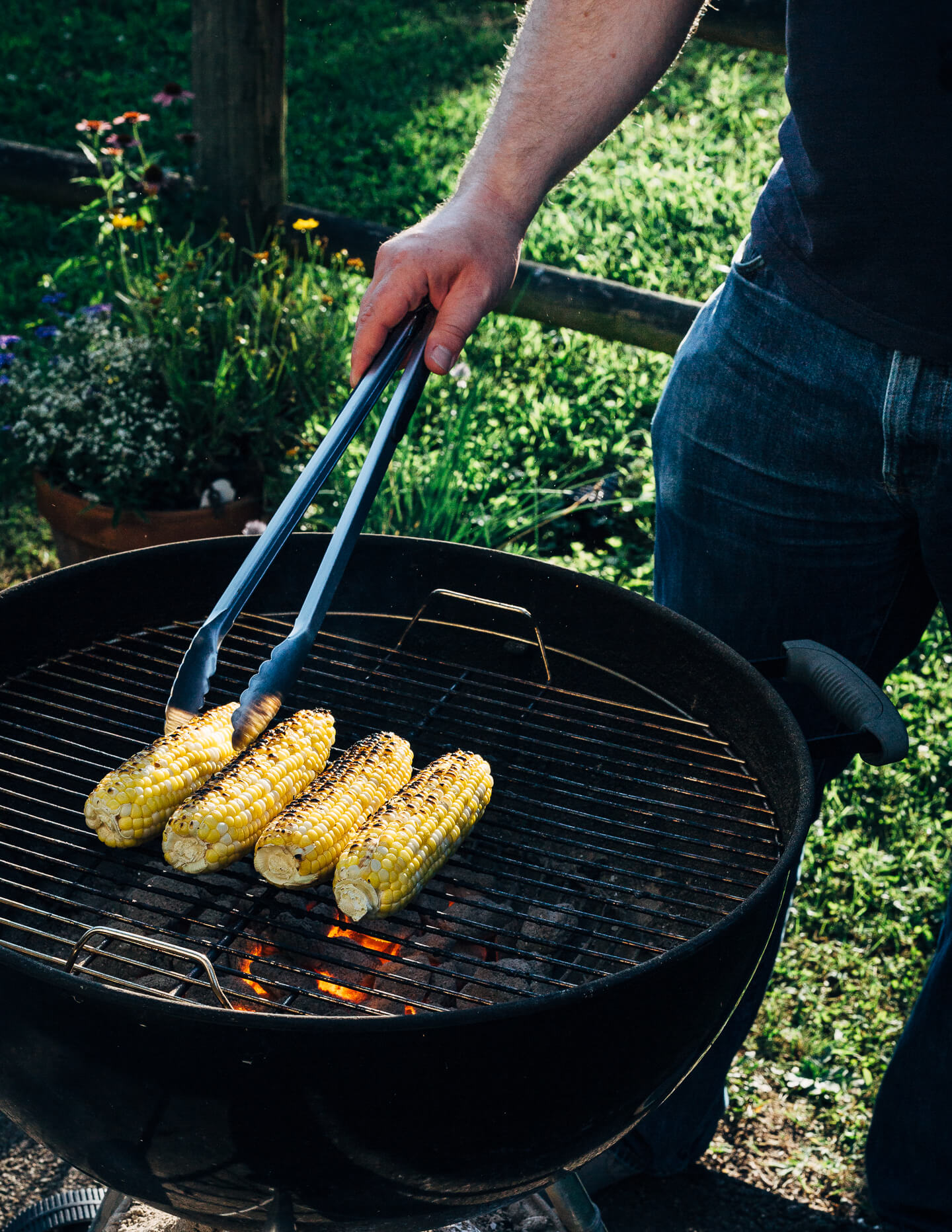 A simple grilled summer feast featuring grilled scallops served atop zucchini noodles tossed with charred corn and fresh herbs.