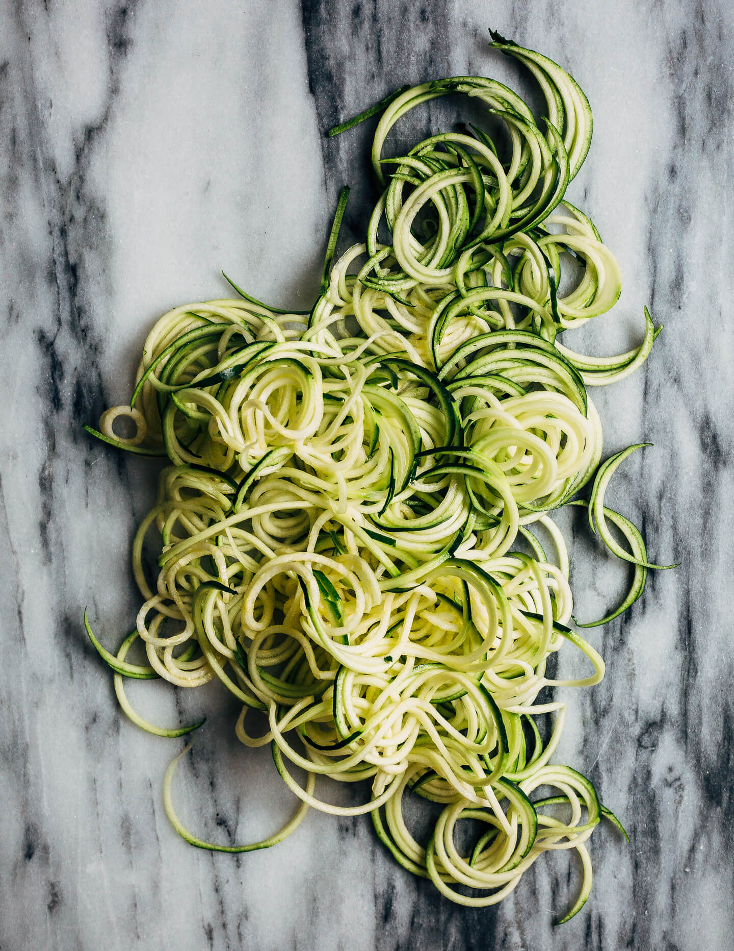 A simple grilled summer feast featuring grilled scallops served atop zucchini noodles tossed with charred corn and fresh herbs.