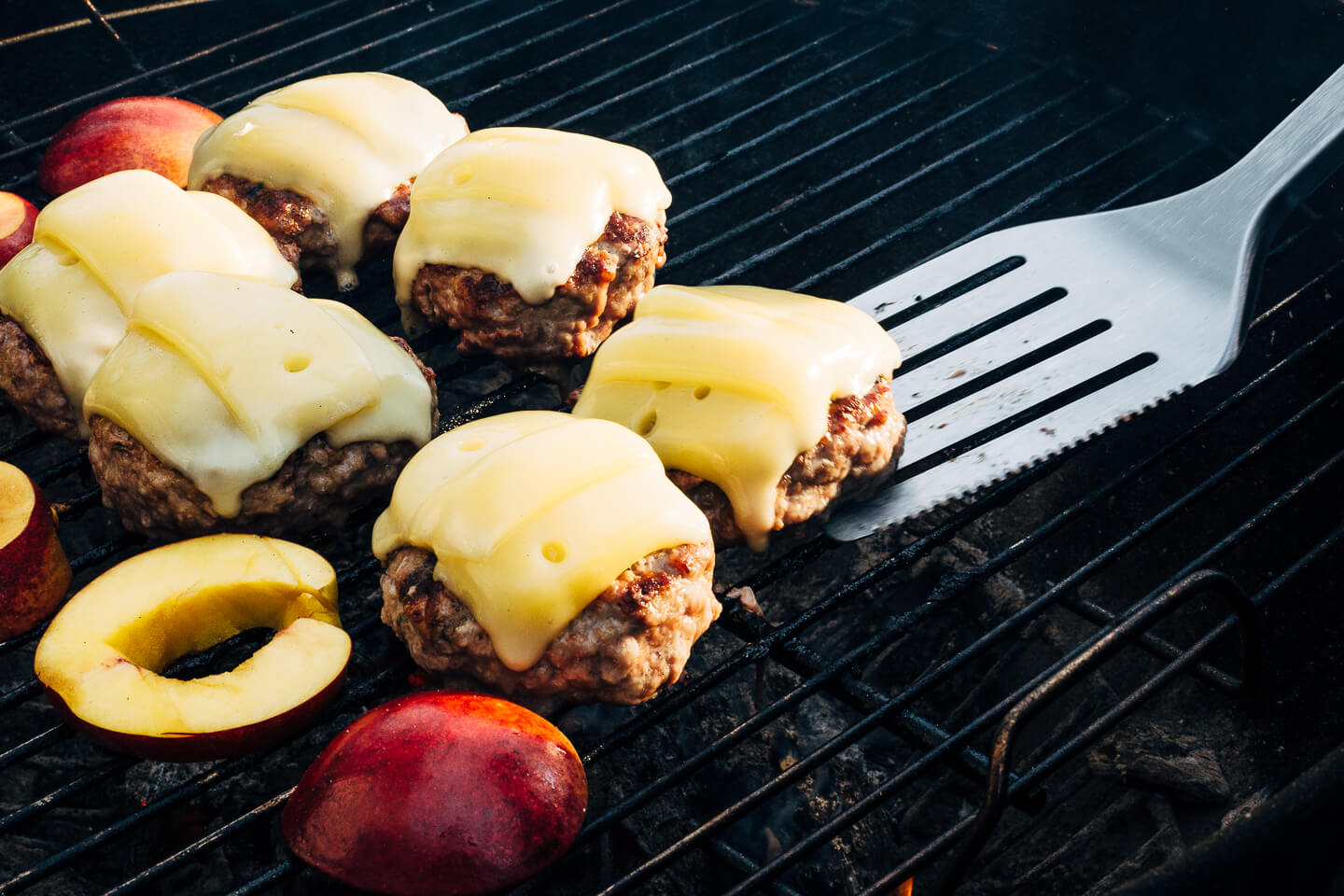 Juicy pork burgers perfectly grilled and topped with velvety melted Raclette cheese, grilled nectarine slices, crisp pickled red onions, and a smear of mayo.