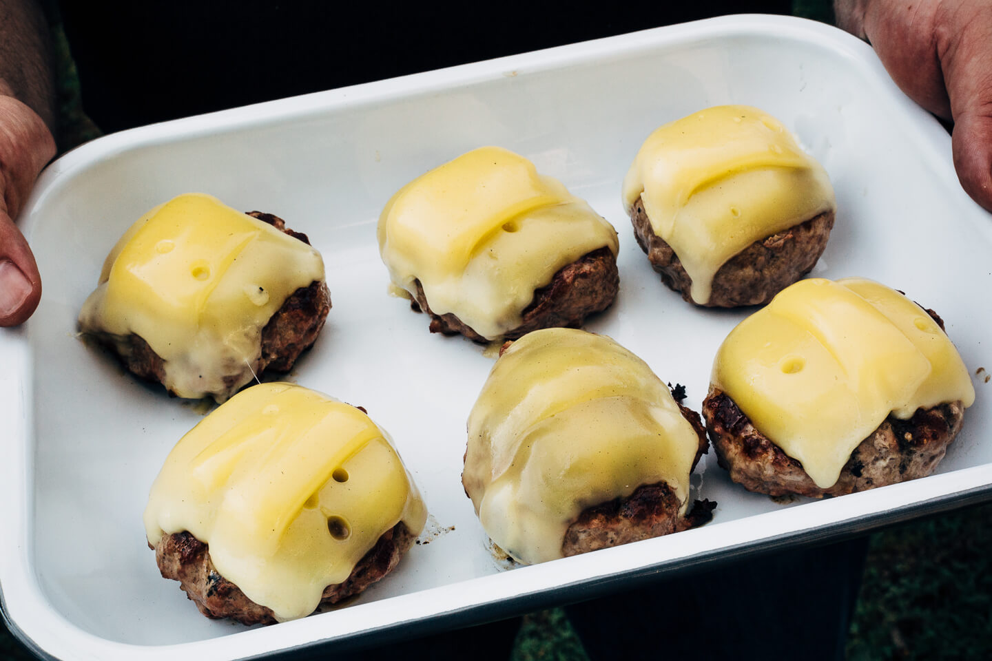 Juicy pork burgers perfectly grilled and topped with velvety melted Raclette cheese, grilled nectarine slices, crisp pickled red onions, and a smear of mayo.