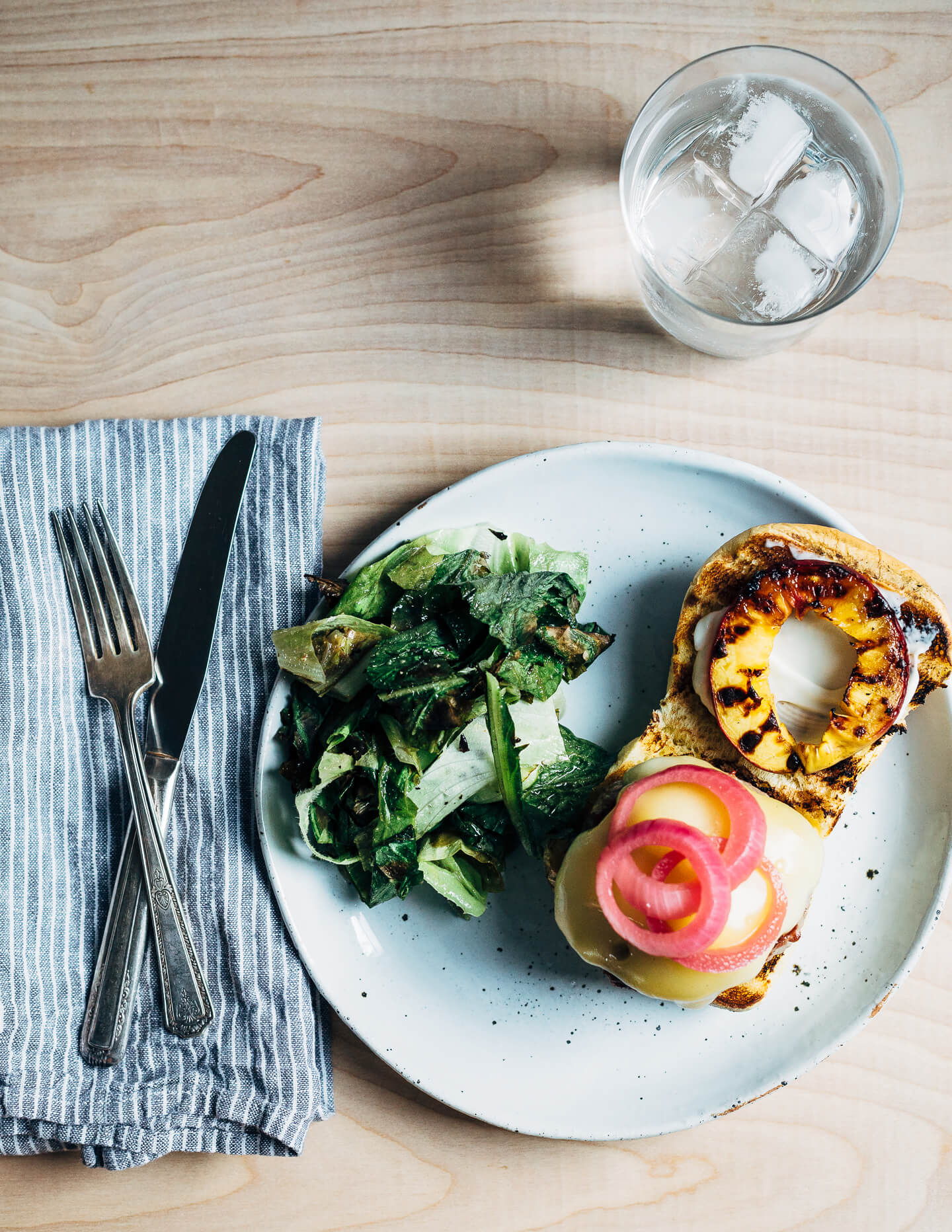 Juicy pork burgers perfectly grilled and topped with velvety melted Raclette cheese, grilled nectarine slices, crisp pickled red onions, and a smear of mayo.