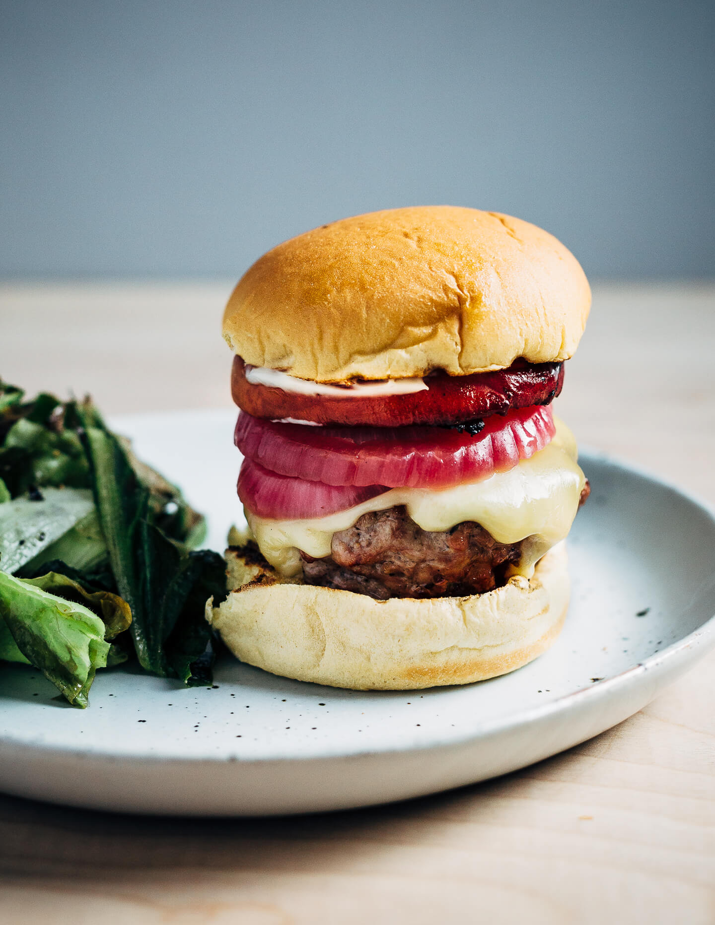 Juicy pork burgers perfectly grilled and topped with velvety melted Raclette cheese, grilled nectarine slices, crisp pickled red onions, and a smear of mayo.