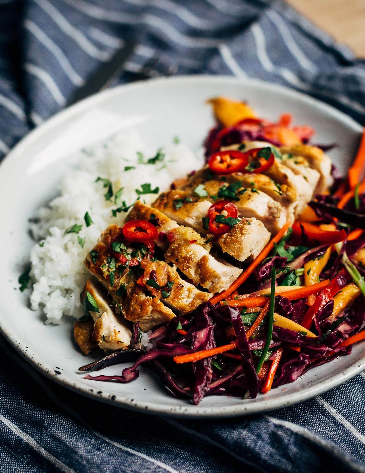 Inspired by Thai flavors, this meal prep chicken features juicy pan-seared chicken breast is served alongside a vibrant red cabbage and mango slaw and sticky jasmine rice.