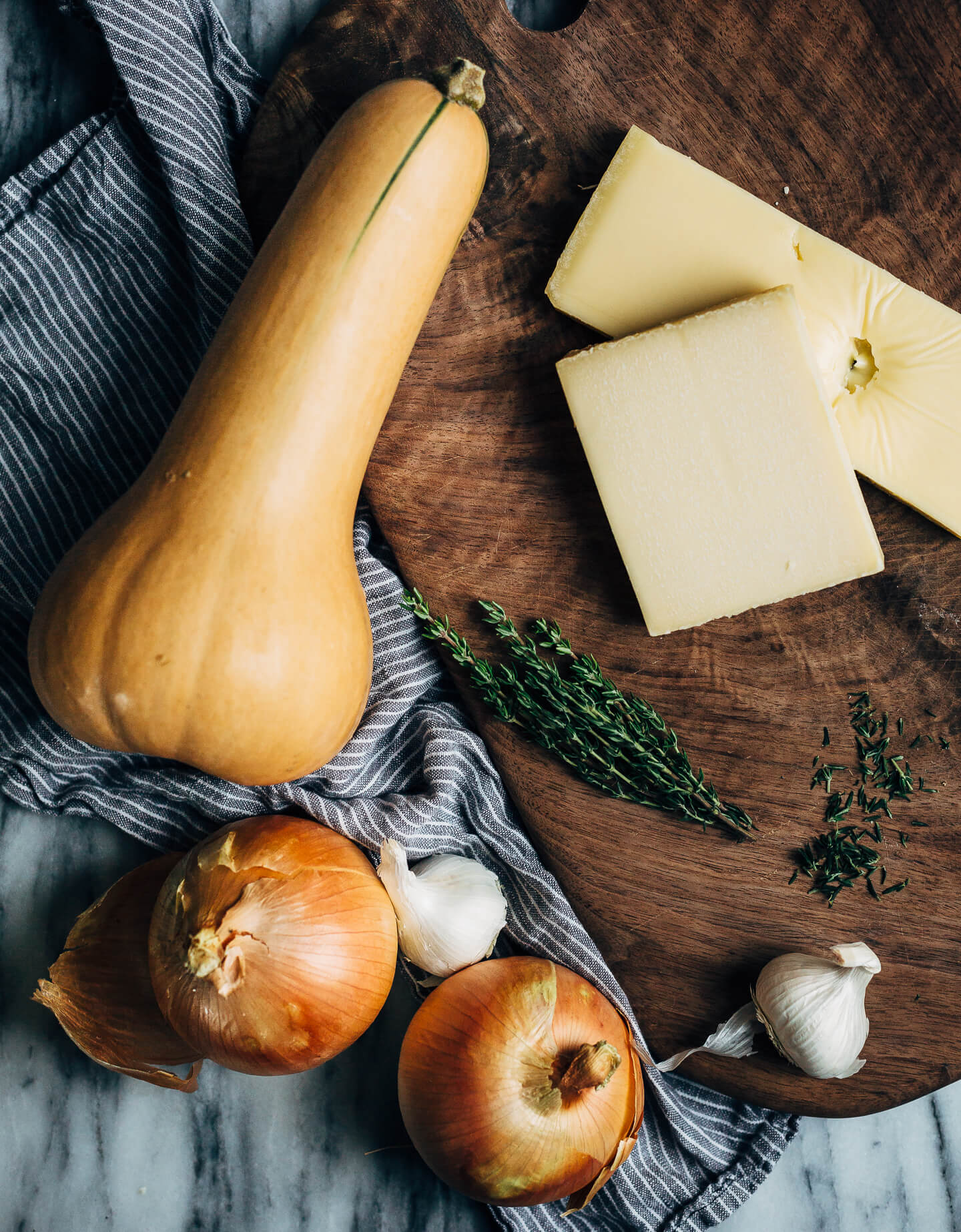 An autumnal butternut squash gratin made with a mix of Emmentaler and Gruyere cheeses, fresh thyme, and bay leaves. This hearty gratin is perfect as part of a cozy fall supper or as a Thanksgiving side.