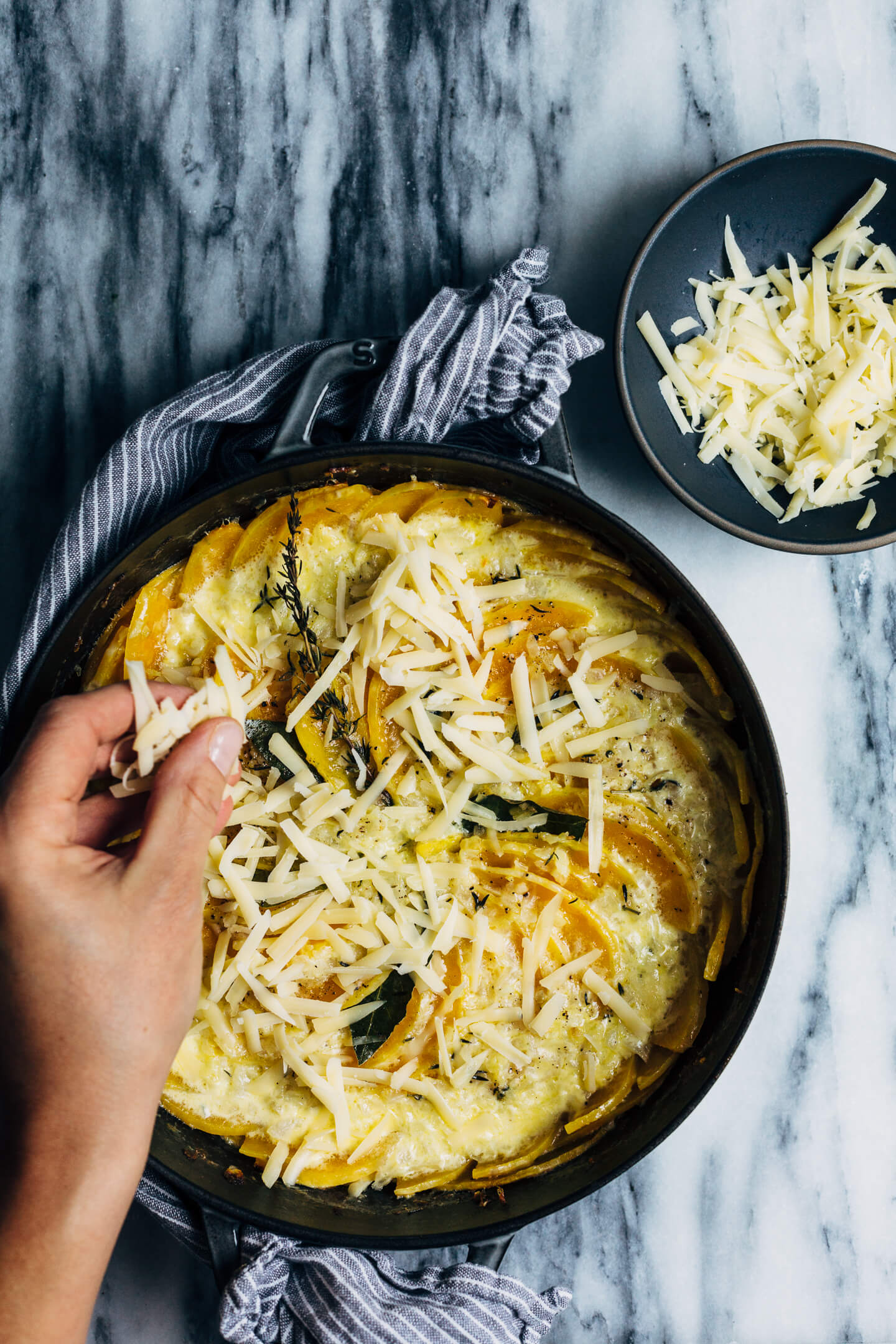 An autumnal butternut squash gratin made with a mix of Emmentaler and Gruyere cheeses, fresh thyme, and bay leaves. This hearty gratin is perfect as part of a cozy fall supper or as a Thanksgiving side.