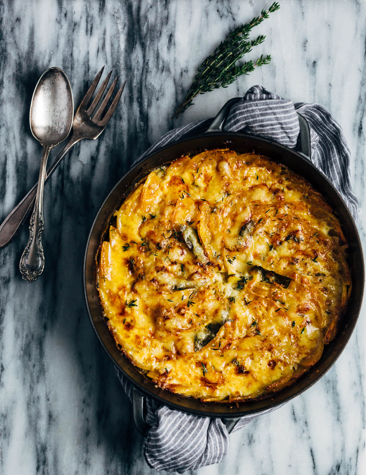 An autumnal butternut squash gratin made with a mix of Emmentaler and Gruyere cheeses, fresh thyme, and bay leaves. This hearty gratin is perfect as part of a cozy fall supper or as a Thanksgiving side.