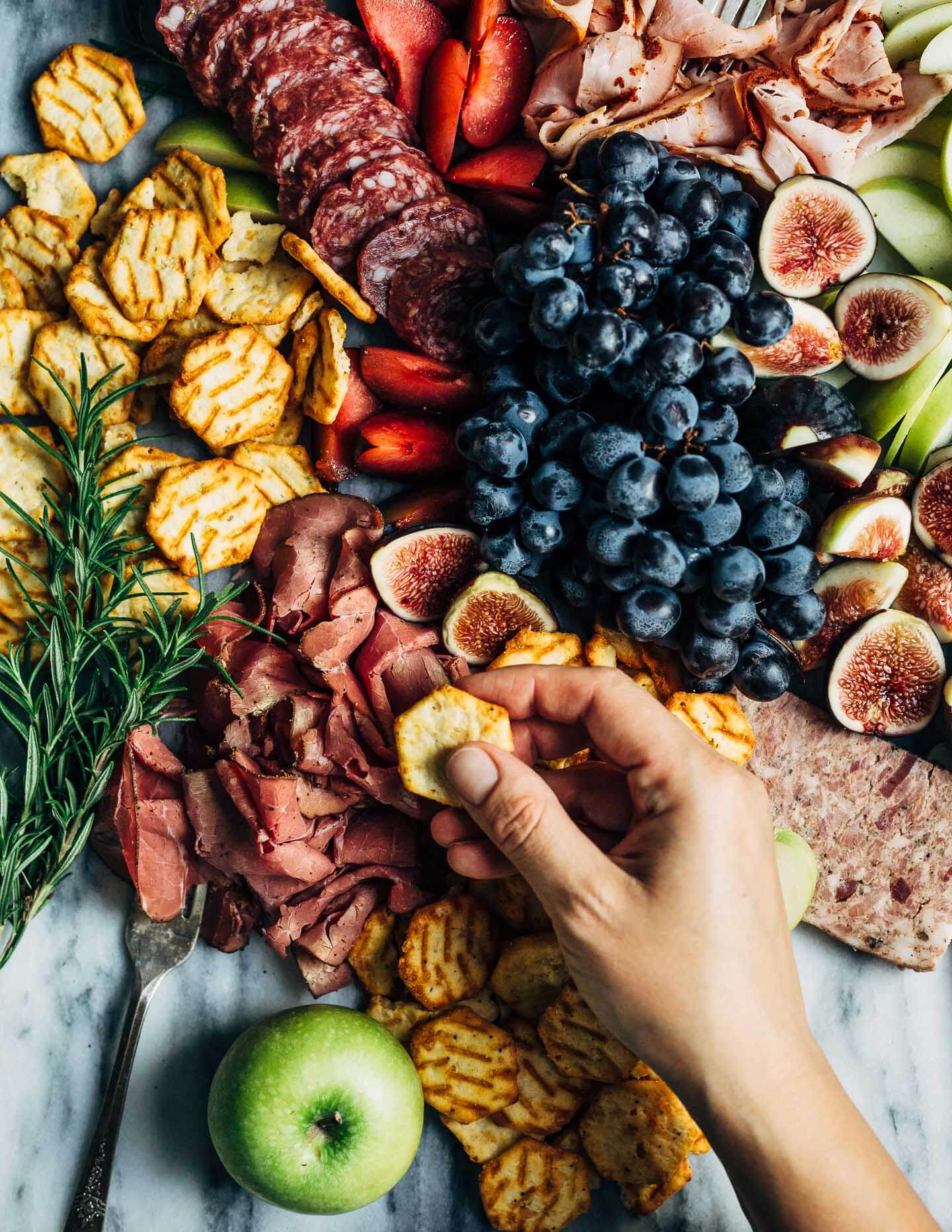 A creative charcuterie graze board that doubles as an eye-catching centerpiece for autumn gatherings. Featuring an assortment of meats, fresh fall fruit, and cheese crisps this charcuterie graze board comes together in minutes.